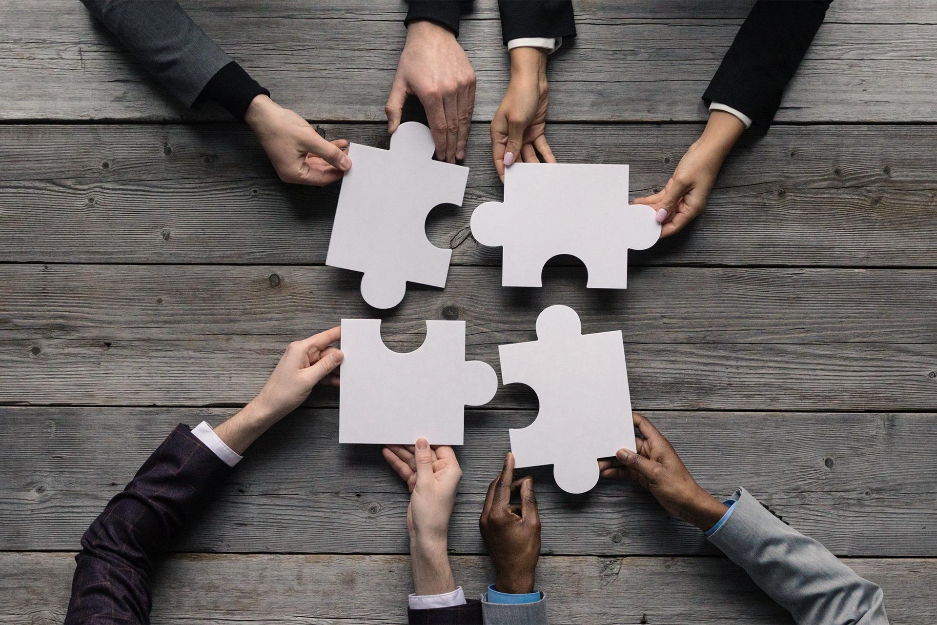 Des mains assemblent les pièces d’un puzzle